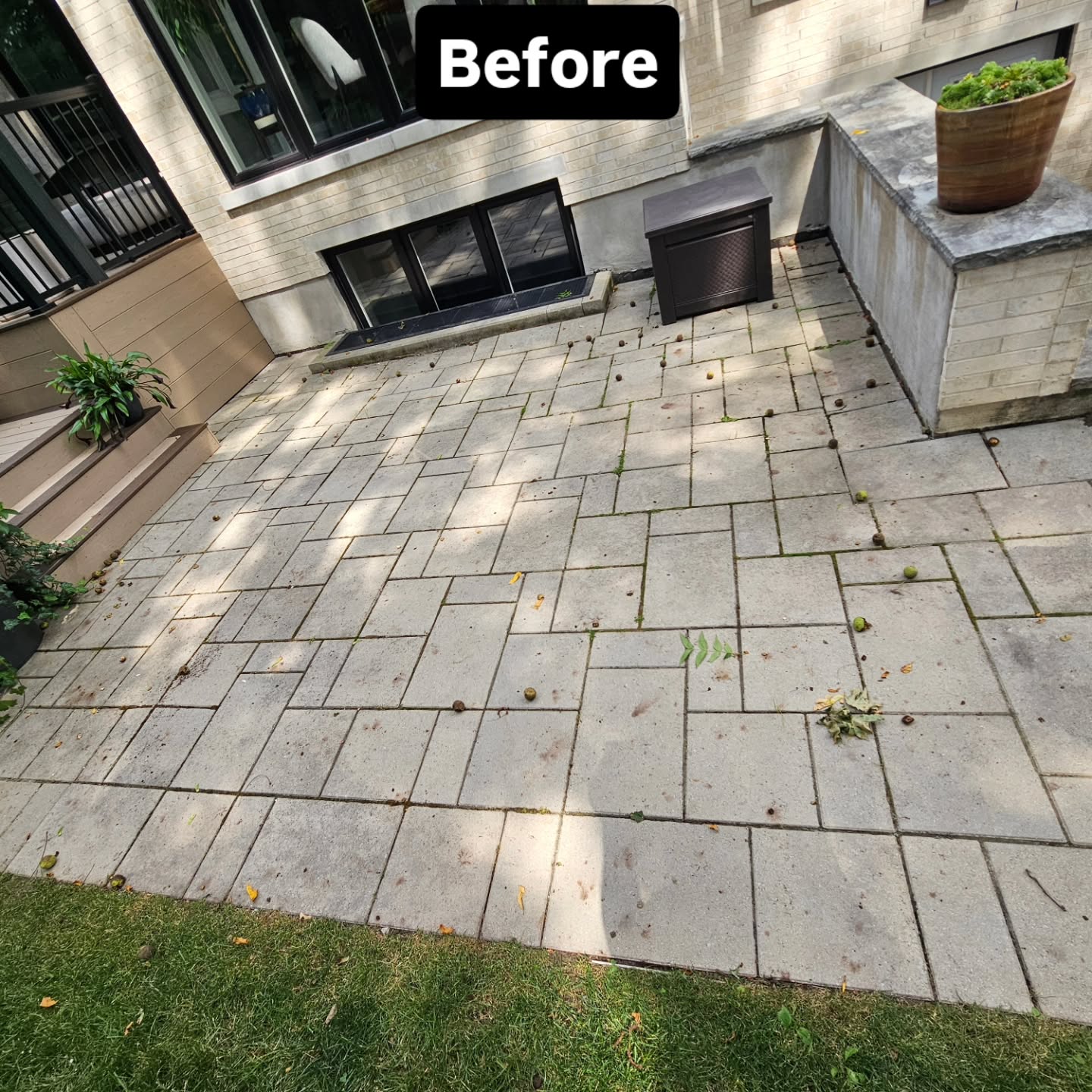 Wider view of the original patio before work, with shifted slabs and gaps across the whole surface