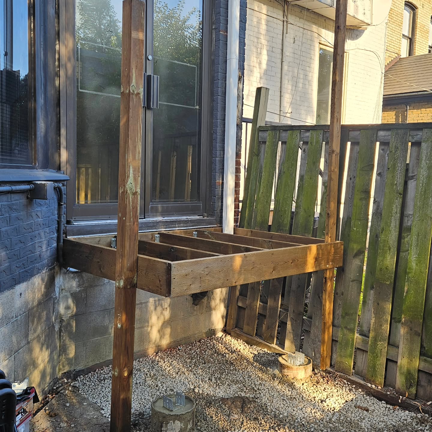New pressure-treated deck frame and posts built off the house wall