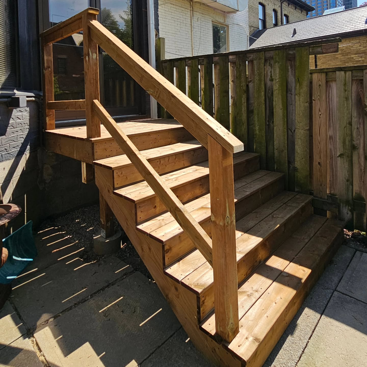 The completed deck landing, stairs and railing at the rear of the home