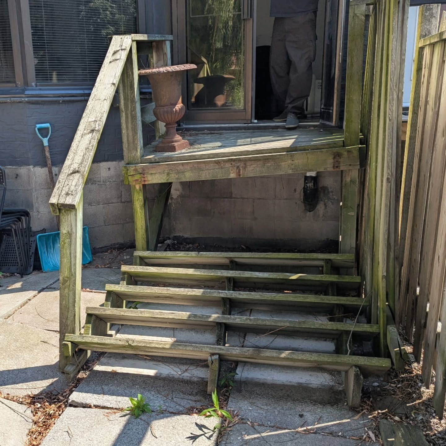 The original rear deck and stairs before the rebuild, with weathered, moss-covered boards and missing treads